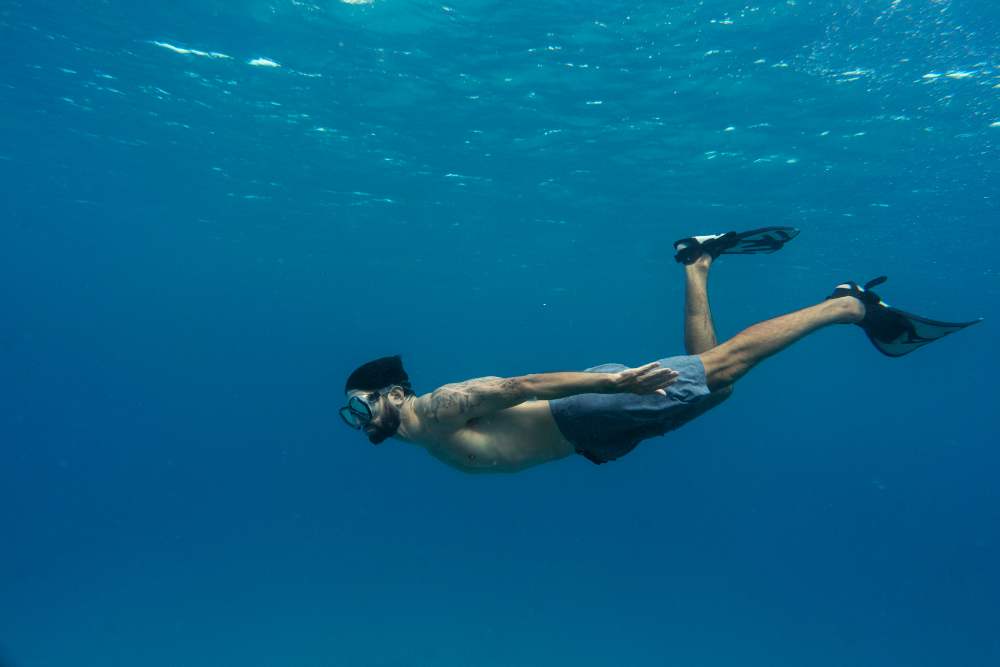 man-freediving-with-flippers-underwater